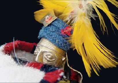 The llautu on this ceremonial doll is the blue band below the feathers. The color of the llautu and the orejones show the doll represents a high-ranking Inca official.
